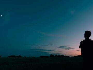silhouette of man looking star during sunset