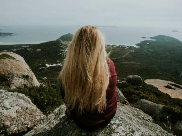 woman sitting on top mountain