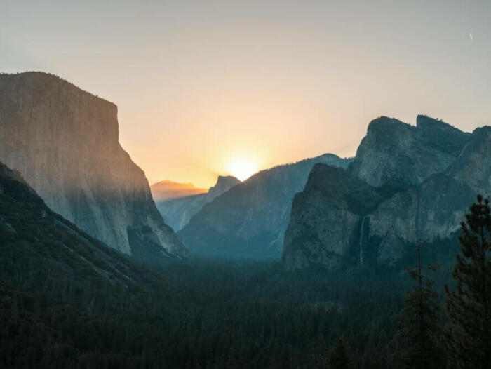 the sun is setting over a mountain range