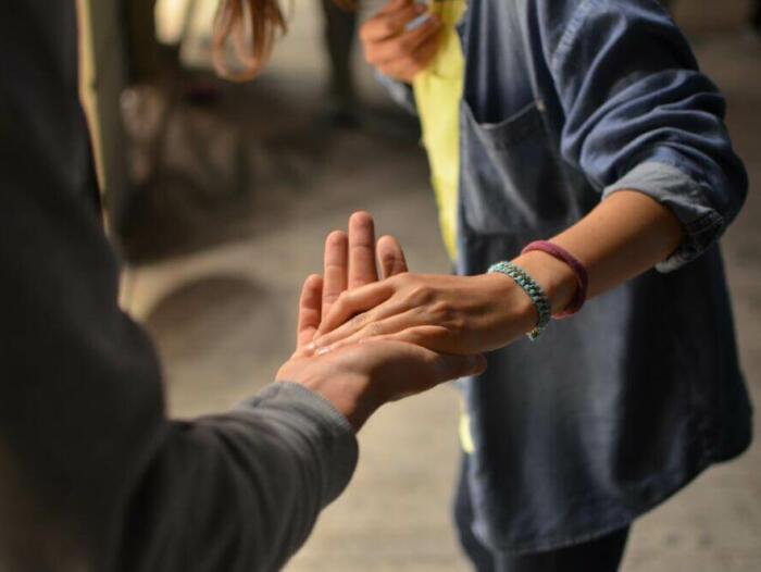 man and woman holding hands on street