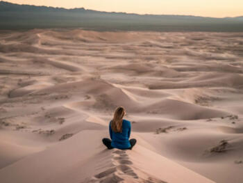 woman sitting on sand field